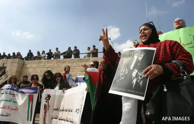 Women, holding Palestinian flags, shout slogans for the release of Hanaa al-Shalabi, a Palestinian woman freed in a prisoner swap with Israel but was re-arrested on February 16 2012, and has gone on hunger strike since,...