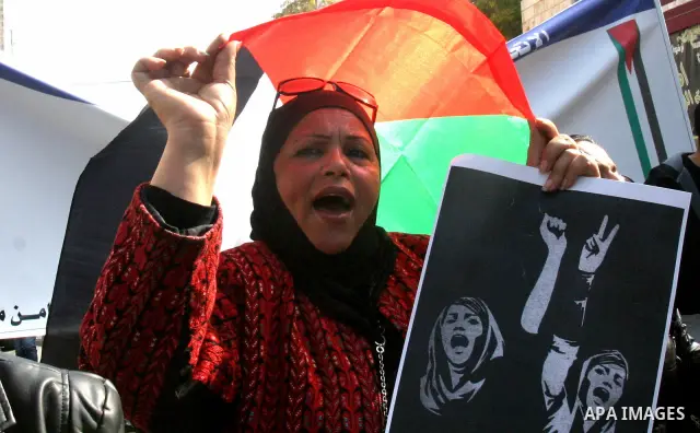 Women, holding Palestinian flags, shout slogans for the release of Hanaa al-Shalabi, a Palestinian woman freed in a prisoner swap with Israel but was re-arrested on February 16 2012, and has gone on hunger strike since,...