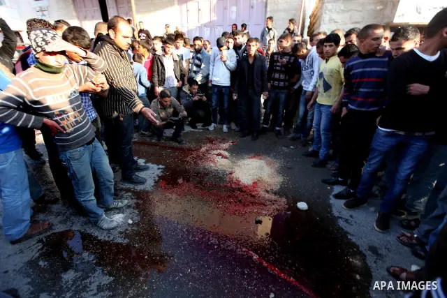 Palestinians contemplate place of the dead body of Zakarya Abu Eram, who was shot dead by an Israeli soldier during an Israeli military operation in the village of Yatta, south of the West Bank town of Hebron, 08 March 2...