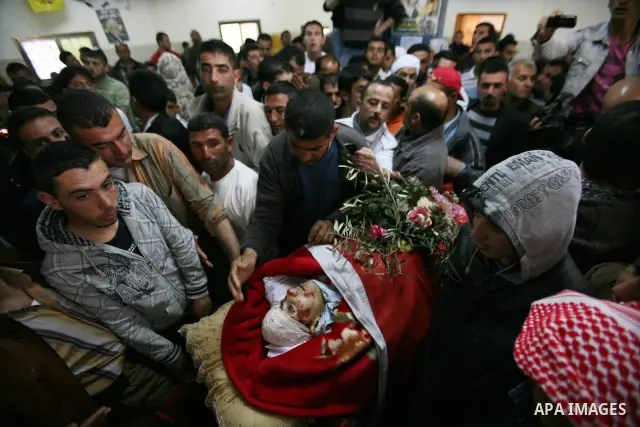 Palestinians looks the body of Zakariya Abu Eram during his funeral in the West Bank town of Yatta, near Hebron, Friday, March 9, 2012. According to the Israeli military, a Palestinian stabbed an Israeli soldier in the n...
