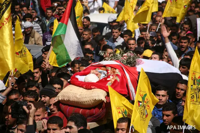 Palestinians carry the body of Zakariya Abu Eram during his funeral in the West Bank town of Yatta, near Hebron, Friday, March 9, 2012. According to the Israeli military, a Palestinian stabbed an Israeli soldier in the n...
