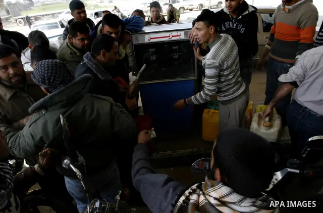 Palestinians wait to fill containers with fuel at a petrol station in Khan Younis in the southern Gaza Strip March 8, 2012. Palestinian Islamist group Hamas faces growing discontent in its Gaza stronghold because of rene...