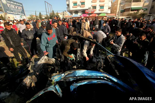 Palestinians look at the remains of a vehicle after it exploded in Gaza City March 9, 2012. Israel killed the leader of a Palestinian militant faction on Friday in a targeted attack on the car in the Gaza Strip, an Israe...