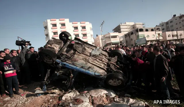 Palestinians look at the remains of a vehicle after it exploded in Gaza City March 9, 2012. Israel killed the leader of a Palestinian militant faction on Friday in a targeted attack on the car in the Gaza Strip, an Israe...