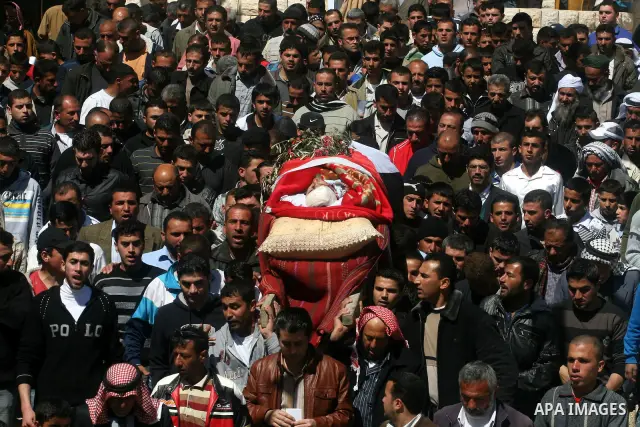 Palestinians carry the body of Zakariya Abu Eram during his funeral in the West Bank town of Yatta, near Hebron, Friday, March 9, 2012. According to the Israeli military, a Palestinian stabbed an Israeli soldier in the n...
