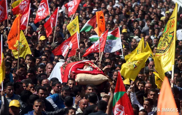 Palestinians carry the body of Zakariya Abu Eram during his funeral in the West Bank town of Yatta, near Hebron, Friday, March 9, 2012. According to the Israeli military, a Palestinian stabbed an Israeli soldier in the n...