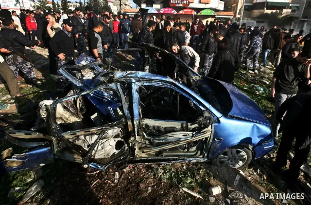 Palestinians look at the remains of a vehicle after it exploded in Gaza City March 9, 2012. Israel killed the leader of a Palestinian militant faction on Friday in a targeted attack on the car in the Gaza Strip, an Israe...