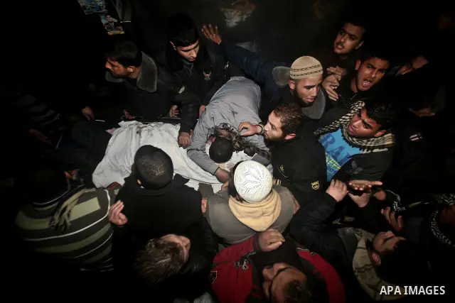 Palestinians mourn in a hospital over the body of one of two militants of the Al Quds Brigades, the military arm of Islamic Jihad, after they were killed in a second Israeli air strike in Gaza City on March 9, 2012, brin...