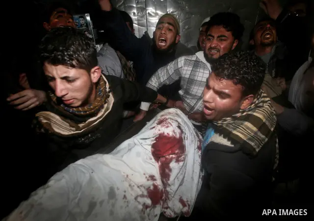 Palestinians mourn in a hospital over the body of one of two militants of the Al Quds Brigades, the military arm of Islamic Jihad, after they were killed in a second Israeli air strike in Gaza City on March 9, 2012, brin...