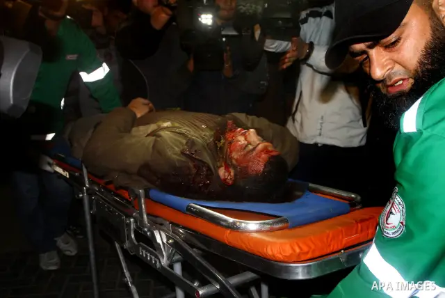 Palestinians mourn in a hospital over the body of one of two militants of the Al Quds Brigades, the military arm of Islamic Jihad, after they were killed in a second Israeli air strike in Gaza City on March 9, 2012, brin...