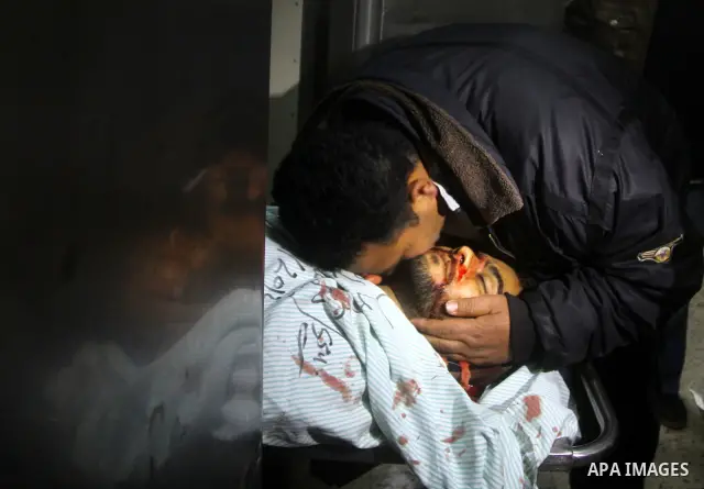Palestinians mourn in a hospital over the body of one of two militants of the Al Quds Brigades, the military arm of Islamic Jihad, after they were killed in a second Israeli air strike in Gaza City on March 9, 2012, brin...