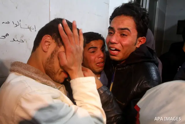 Palestinians mourn in a hospital over the body of one of two militants of the Al Quds Brigades, the military arm of Islamic Jihad, after they were killed in a second Israeli air strike in Gaza City on March 9, 2012, brin...