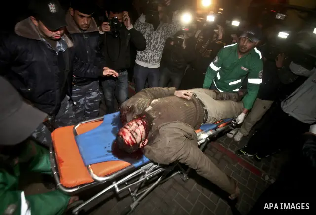 Palestinians mourn in a hospital over the body of one of two militants of the Al Quds Brigades, the military arm of Islamic Jihad, after they were killed in a second Israeli air strike in Gaza City on March 9, 2012, brin...