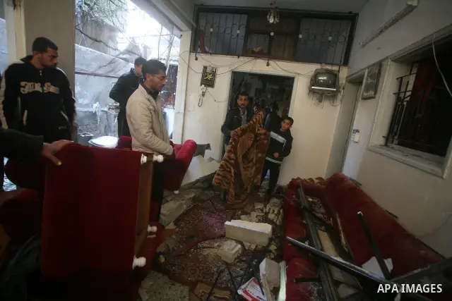 Palestinians inspect damage in their house in Al Shijaia Neighborhood in Gaza city, after an Israeli air strike in Gaza City on 10 March 2012, bringing the number of Palestinians killed in a day of cross-border fighting...