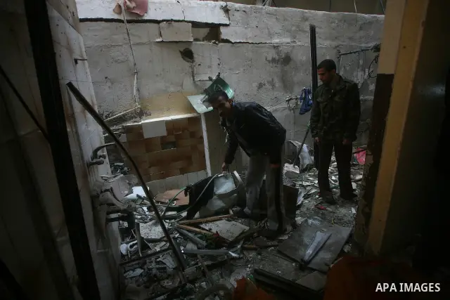 Palestinians inspect damage in their house in Al Shijaia Neighborhood in Gaza city, after an Israeli air strike in Gaza City on 10 March 2012, bringing the number of Palestinians killed in a day of cross-border fighting...