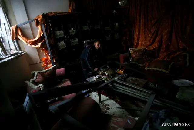 Palestinians inspect damage in their house in Al Shijaia Neighborhood in Gaza city, after an Israeli air strike in Gaza City on 10 March 2012, bringing the number of Palestinians killed in a day of cross-border fighting...