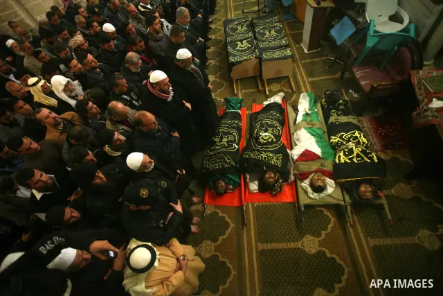 Palestinians pray near the bodies of Islamic Jihad militants during their funeral in Gaza March 10, 2012. Israel killed two more Gaza militants on Saturday, raising the death toll in two days of violence to 12 and dozens...
