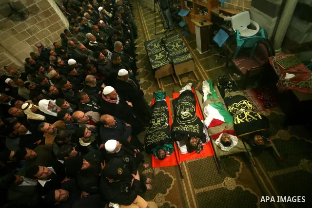 Palestinians pray near the bodies of Islamic Jihad militants during their funeral in Gaza March 10, 2012. Israel killed two more Gaza militants on Saturday, raising the death toll in two days of violence to 12 and dozens...
