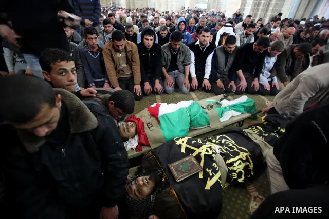 Palestinians pray near the bodies of Islamic Jihad militants during their funeral in Gaza March 10, 2012. Israel killed two more Gaza militants on Saturday, raising the death toll in two days of violence to 12 and dozens...