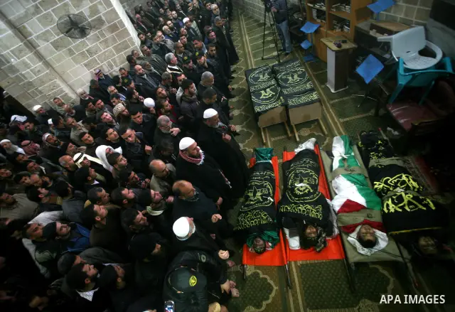 Palestinians pray near the bodies of Islamic Jihad militants during their funeral in Gaza March 10, 2012. Israel killed two more Gaza militants on Saturday, raising the death toll in two days of violence to 12 and dozens...