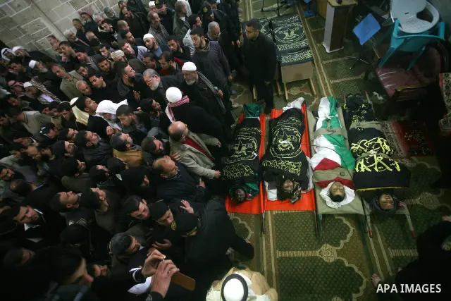 Palestinians pray near the bodies of Islamic Jihad militants during their funeral in Gaza March 10, 2012. Israel killed two more Gaza militants on Saturday, raising the death toll in two days of violence to 12 and dozens...