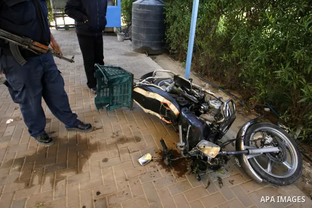 Palestinians inspect a motorcycle that was hit in an Israeli air strike in Khan Younis in the southern Gaza Strip March 10, 2012. Israel killed four Gaza militants on Saturday as violence sparked by the death of a milita...