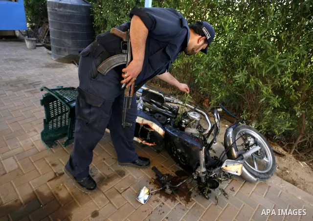 Palestinians inspect a motorcycle that was hit in an Israeli air strike in Khan Younis in the southern Gaza Strip March 10, 2012. Israel killed four Gaza militants on Saturday as violence sparked by the death of a milita...