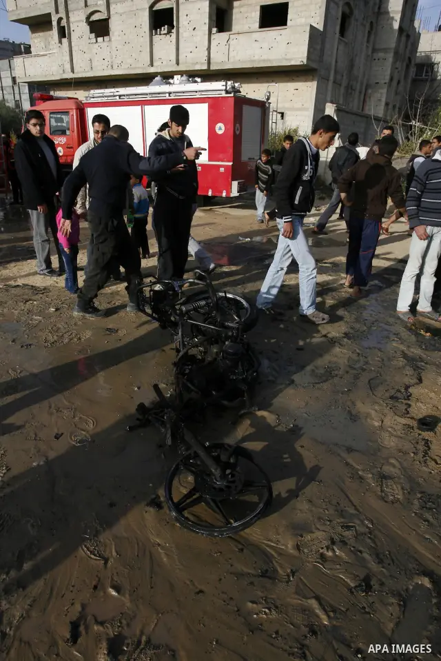 Palestinians inspect the damage of a motorcycle bombing executed by an Israeli airstrike in Rafah, southern Gaza Strip, Saturday, March 10, 2012. The airstrike killed Popular Resistance Committees militant Mahdi Abu Shaw...