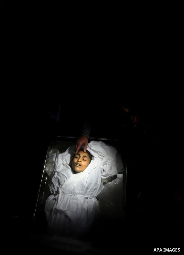 Relatives of Ayoub Assalya, 12-year-old, look at his body in the morgue of Kamal Edwan hospital in Beit Lahia in the northern Gaza Strip, on March 11, 2012, following a fresh Israeli air raid, bringing the death toll fro...
