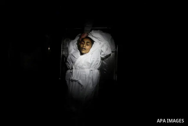 Relatives of Ayoub Assalya, 12-year-old, look at his body in the morgue of Kamal Edwan hospital in Beit Lahia in the northern Gaza Strip, on March 11, 2012, following a fresh Israeli air raid, bringing the death toll fro...