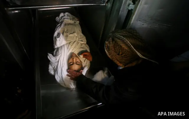 Relatives of Ayoub Assalya, 12-year-old, look at his body in the morgue of Kamal Edwan hospital in Beit Lahia in the northern Gaza Strip, on March 11, 2012, following a fresh Israeli air raid, bringing the death toll fro...