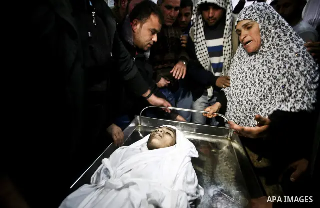 The mother of Ayoub Asalya, 12-year-old, bids fare well to her son in the morgue of Kamal Edwan hospital in Beit Lahia in the northern Gaza Strip, on March 11, 2012, following a fresh Israeli air raid, bringing the death...
