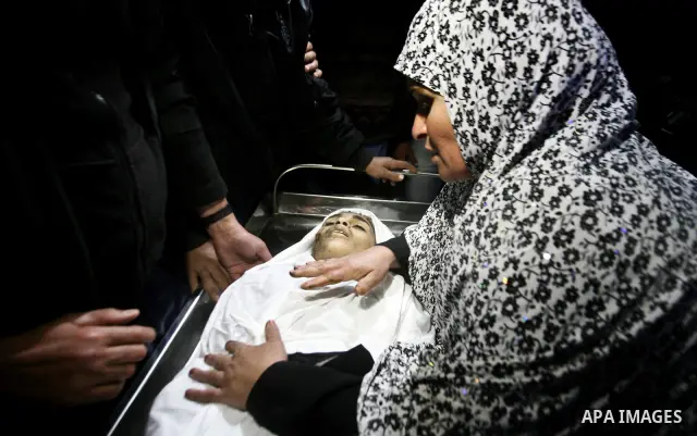 The mother of Ayoub Asalya, 12-year-old, bids fare well to her son in the morgue of Kamal Edwan hospital in Beit Lahia in the northern Gaza Strip, on March 11, 2012, following a fresh Israeli air raid, bringing the death...