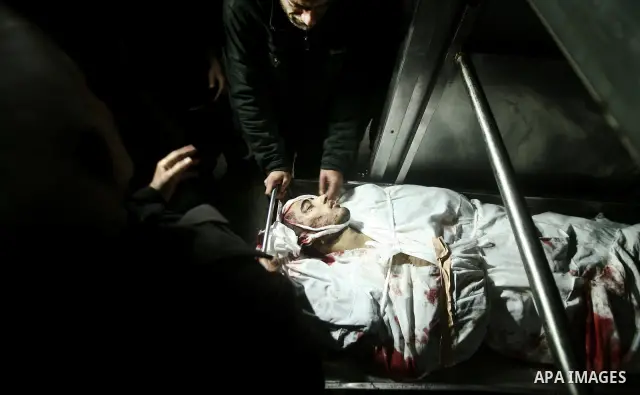 Relatives of Ahmed salem, 22-year-old, look at his body in the morgue of Al-Shifa hospital in Gaza City, on March 11, 2012, following a fresh Israeli air raid, bringing the death toll from strikes since March 10 to 17 an...