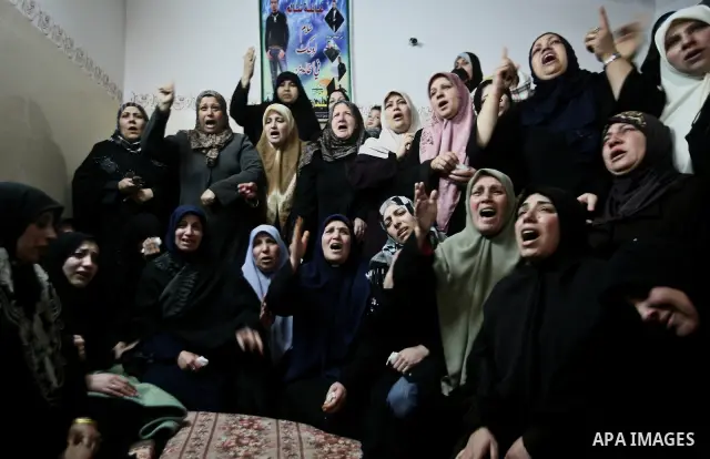 Palestinian relatives of Ahmed Salim, one of the Nasser Salah Addin Brigades who was killed in an Israeli air strike, mourn during his funeral in Gaza City,Sunday, March 11, 2012. Medics said Israeli air strikes on the G...
