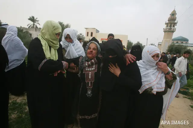The mother of a Palestinian militant mourns next to his body (not seen) at the scene of an Israeli air strike in Khan Younis in the southern Gaza Strip March 12, 2012. Israeli air strikes killed two Palestinian militants...