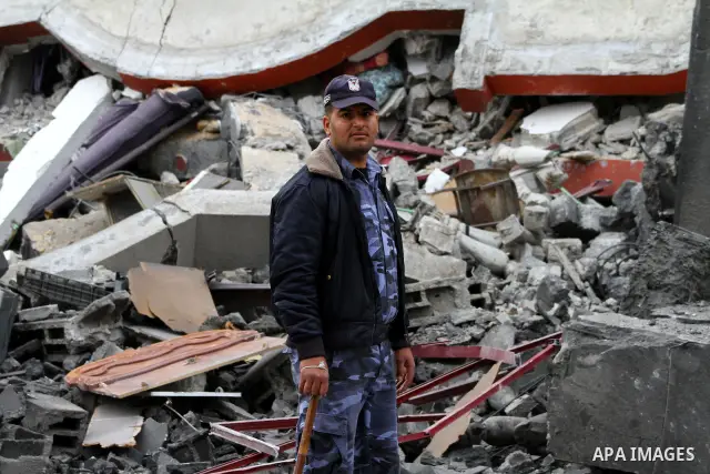 A Palestinian policeman inspects destruction after an Israeli air strike on a building in the northern Gaza Strip refugee camp of Jabalia on March 12, 2012. Israel launched a spate of air strikes killing at least two Pal...
