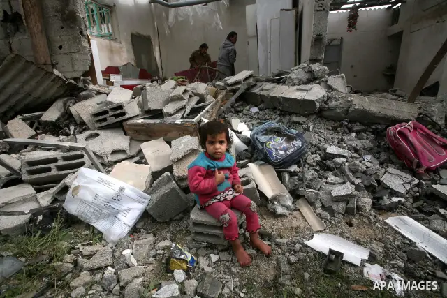 A Palestinian child sit in front of their house, destroyed after an Israeli air strike in Jabalya in the northern Gaza Strip. A recent wave of Israel bombings have reported to have killed at least 20. Photo by Ashraf Amr...