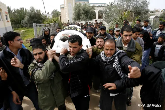 Palestinian mourners carry the body of Raafat Abu Eid , 24-years-old, a member of the Islamic Jihad's armed wing, the Al-Quds Brigades, during his funeral in Khan Yunis in the southern Gaza Strip, on March 12, 2012. Eid...