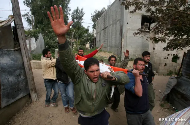 Palestinian carry the body of Mohammed al-Hasoma, 65, killed in an Israeli air strike during his funeral in Beit Lahiya, northern Gaza Strip, Monday, March 12, 2012. The cross-border violence, touched off by Israel's kil...