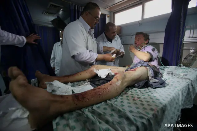 A wounded Palestinian boy is wheeled into a hospital in Gaza City, after an Israeli air strike March 12, 2012. Israeli air strikes killed two Palestinian militants and a civilian in the Gaza Strip on Monday in a fourth d...