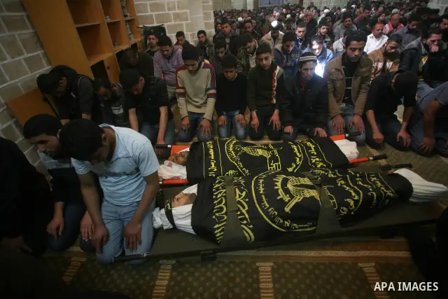 Palestinians pray on the bodies of two Islamic Jihad militants Mohammed Daher, left, and Bassam Al Ejla killed in an Israeli air strike in Gaza Tuesday, during their funeral in Gaza City, Tuesday, March 13, 2012 . Israel...