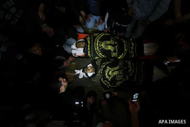 Palestinians mourn beside the bodies of two Islamic Jihad militants Mohammed Daher, left, and Bassam Al Ejla killed in an Israeli air strike in Gaza Tuesday, during their funeral in Gaza City, Tuesday, March 13, 2012 . I...