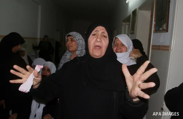 Palestinian relatives of Islamic Jihad militant Bassam El-Ejla, who was killed the night before along with another comrade in an Israeli air strike, mourn during his funeral in Gaza City on March 13, 2012. Israel and mil...