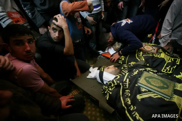 Palestinians mourn beside the bodies of two Islamic Jihad militants Mohammed Daher, left, and Bassam Al Ejla killed in an Israeli air strike in Gaza Tuesday, during their funeral in Gaza City, Tuesday, March 13, 2012 . I...