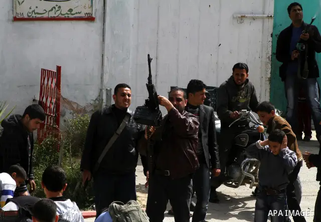 A Palestinian fires a weapon in the air during the funeral of Islamic Jihad militant Mohammed Daher in Gaza City March 13, 2012. An Egyptian-brokered truce between Israel and militant groups in the Gaza Strip began to ta...