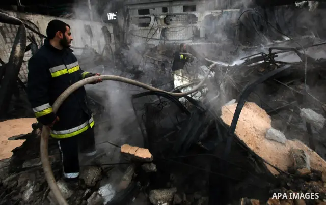 Palestinian firemen extinguish a fire at a building on March 14, 2012, after an Israeli air strike on Gaza City. Israel and militants in Gaza began observing an Egyptian-brokered truce on March 13, after four days of vio...