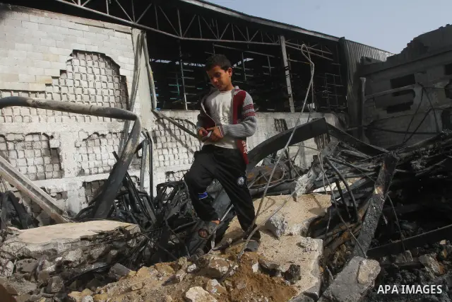Palestinians inspect destroyed buildings on March 14, 2012, following an Israeli air strike on Gaza City. Israel and militants in Gaza began observing an Egyptian-brokered truce on March 13, after four days of violence,...