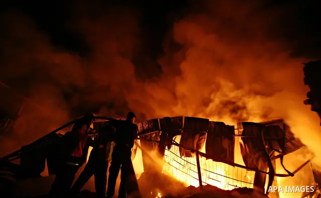Palestinian fire fighters try to extinguish a blaze at a burning factory after an Israeli missile strike in the east of Gaza Strip on 14 March 2012. A fragile truce appeared to be taking hold between Israel and Palestini...