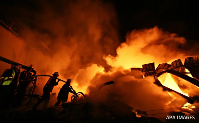 Palestinian fire fighters try to extinguish a blaze at a burning factory after an Israeli missile strike in the east of Gaza Strip on 14 March 2012. A fragile truce appeared to be taking hold between Israel and Palestini...
